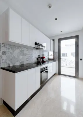 a kitchen with white cabinets and a large window at Spinoza House Suite de luxe Casablanca - Maarif in Casablanca