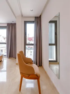 a living room with a chair and a mirror at Spinoza House Suite de luxe Casablanca - Maarif in Casablanca