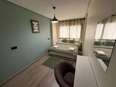 a small room with two beds and a chair at Elegance & Comfort - by Nero in Casablanca