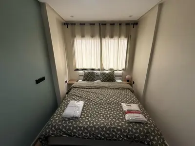 a small bedroom with a bed in front of a window at Elegance & Comfort - by Nero in Casablanca