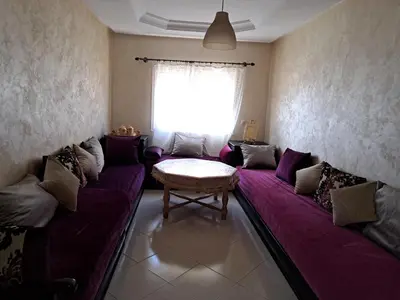 a living room with a purple couch and a window at Chez Fatima - Nassim Gh12 in Mohammedia