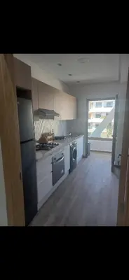 a large kitchen with a stove and a dishwasher at Residence Garden Paradise plage luxe in Bouznika
