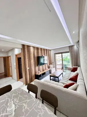 a living room with a large couch and a table at Residence Garden Paradise plage luxe in Bouznika