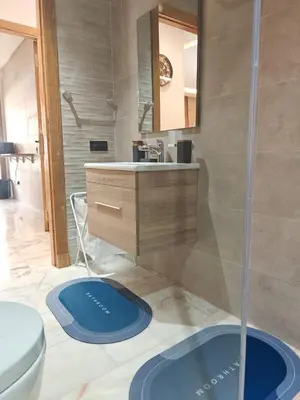 a bathroom with a sink and a toilet and a mirror at L'Écume Des Sablettes in Mohammedia