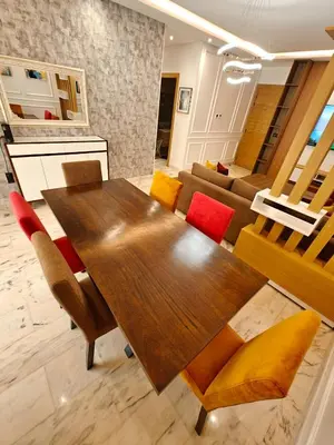 a dining room table with chairs and a couch at Appart Moderne Vue mer latérale & piscine - Plage des Sablettes El Mansouria in O Ben Slimane