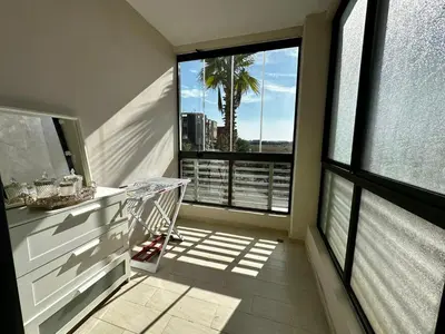 a balcony with a view of a palm tree at APT Luxueux à Costa Beach 3 avec Piscine et accès Plage in Bouznika