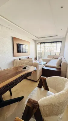 a living room with a couch and a table and chairs at CAN STADIUM VIEW Luxurious Place Prestigia Hay Riad in Rabat