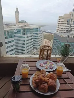 a table with two plates of food and two glasses of orange juice at Joli Studio with Seaview 16 in Casablanca