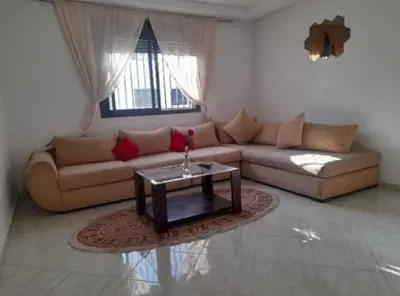 a living room with a couch and a table at En face hôpital M6,Proche Aéroport et nearchore in Oulad Akkou