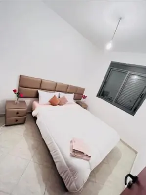 a bedroom with a large white bed with a window at En face hôpital M6,Proche Aéroport et nearchore in Oulad Akkou