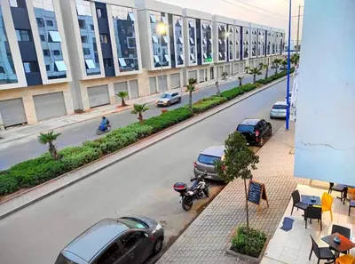 a street with cars parked on the side of a building at En face hôpital M6,Proche Aéroport et nearchore in Oulad Akkou
