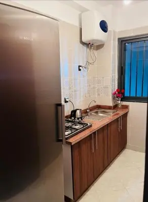 a kitchen with a stainless steel refrigerator and a sink at En face hôpital M6,Proche Aéroport et nearchore in Oulad Akkou