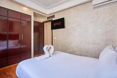 a bedroom with a white bed with a sign on the wall at 2BR Getaway Near and Seaside Promenade in Casablanca