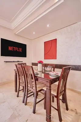 a dining room with a wooden table and chairs at 2BR Getaway Near and Seaside Promenade in Casablanca