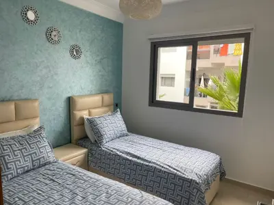 a bedroom with two beds and a window at La perle de blanca beach in Sidi Rahal