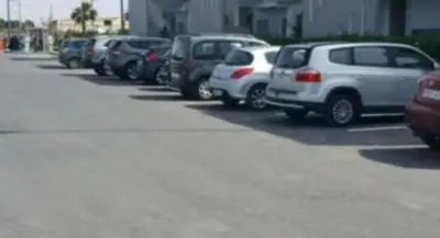 a row of cars parked in a parking lot at La perle de blanca beach in Sidi Rahal
