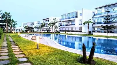 a large swimming pool in front of a building at La perle de blanca beach in Sidi Rahal