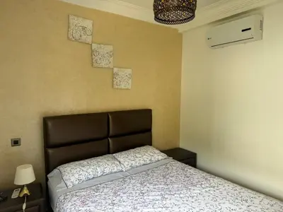 a bedroom with a bed with a brown head board at La perle de blanca beach in Sidi Rahal