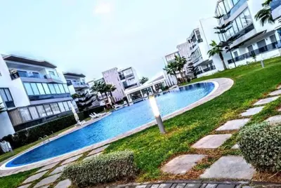 a swimming pool in front of some apartment buildings at La perle de blanca beach in Sidi Rahal