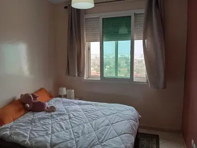 a teddy bear laying on a bed in a bedroom at Sara Appartement in Casablanca