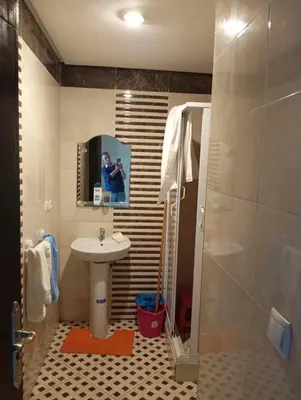 a bathroom with a sink and a shower with a mirror at Sara Appartement in Casablanca
