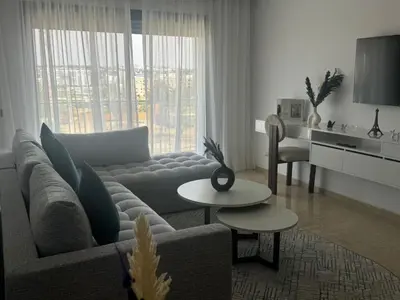 a living room with a couch and a table at Appart idéal Face Gare Agdal in Rabat