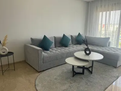 a living room with a couch and a table at Appart idéal Face Gare Agdal in Rabat
