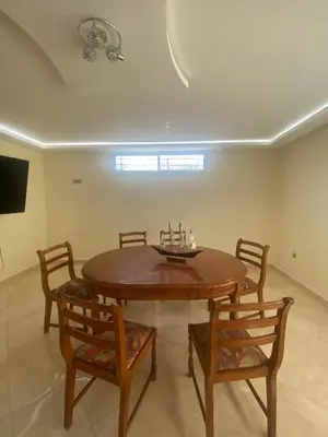 a dining room with a wooden table and chairs at coastal charm harhoura in Temara