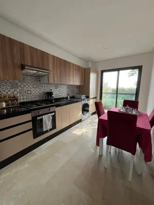 a kitchen with a table and a stove and a counter at Appartement cosy et confortable in Casablanca