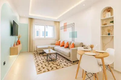 a living room with a couch and a table at Appartement de luxe 2 chambres PS5,AC,Fibre,Netflix à agdal Au coeur de Rabat in Rabat