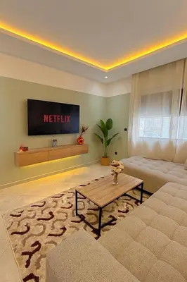 a living room with a couch and a table at Appartement de luxe 2 chambres PS5,AC,Fibre,Netflix à agdal Au coeur de Rabat in Rabat