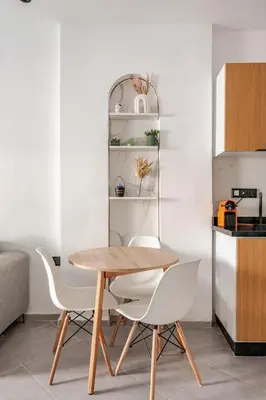 a dining room with a wooden table and white chairs at Appartement de luxe 2 chambres PS5,AC,Fibre,Netflix à agdal Au coeur de Rabat in Rabat