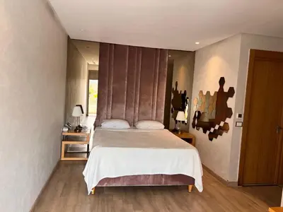 a bedroom with a large bed and a window at Grand appartement la corniche vue panoramique sur Casablanca in Casablanca