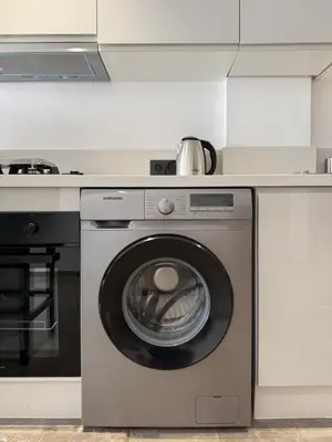 a kitchen with a washing machine under a counter at Adresse exceptionnelle Casablanca in Casablanca