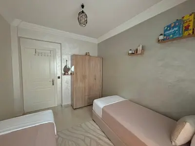 a room with a bed and a cabinet in it at Chez A&J, appartement climatisé, proche du Stade de Rabat in Temara