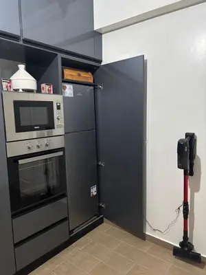a kitchen with a stove and a microwave and a refrigerator at Chez A&J, appartement climatisé, proche du Stade de Rabat in Temara