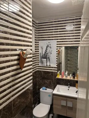 a bathroom with a toilet and a sink at Chez A&J, appartement climatisé, proche du Stade de Rabat in Temara