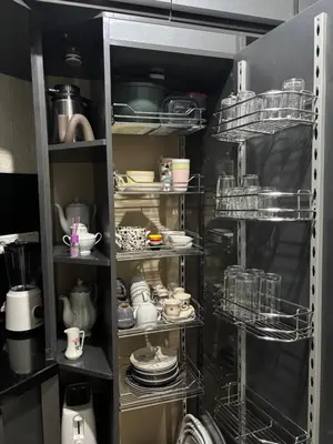 a kitchen pantry with dishes and dishes on shelves at Chez A&J, appartement climatisé, proche du Stade de Rabat in Temara