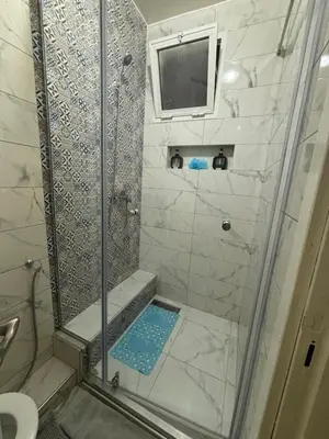 a bathroom with a shower with a television in it at Chez A&J, appartement climatisé, proche du Stade de Rabat in Temara
