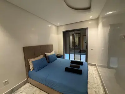 a bedroom with a bed with a blue comforter at Modern studio with large terrace and parking in Casablanca