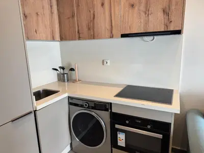 a small kitchen with a stove and a washing machine at Studio en plein centre de Gautier in Casablanca