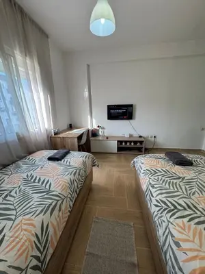 a bedroom with two beds and a tv on the wall at studio ensoleillé á louer Témara, in Temara