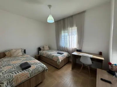 a small bedroom with two beds and a desk at studio ensoleillé á louer Témara, in Temara