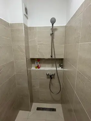 a bathroom with a shower with a shower head at studio ensoleillé á louer Témara, in Temara