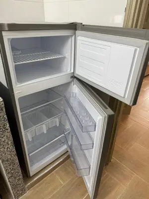 an empty refrigerator with its door open in a kitchen at studio ensoleillé á louer Témara, in Temara