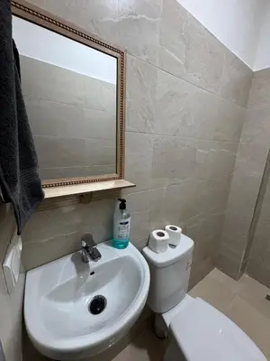 a bathroom with a sink and a toilet and a mirror at studio ensoleillé á louer Témara, in Temara