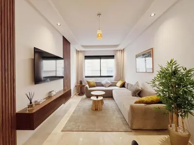 a living room with a couch and a tv at Cosy Central Appart in Casablanca Best Location in Maarif