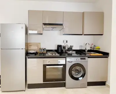 a kitchen with a refrigerator and a washing machine at Cosy Central Appart in Casablanca Best Location in Maarif