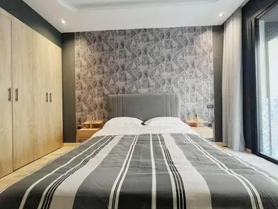 a bedroom with a large bed in front of a wall at Cosy Central Appart in Casablanca Best Location in Maarif