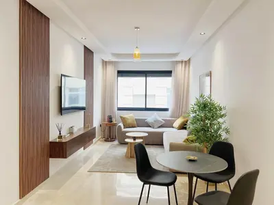 a living room with a couch and a table and chairs at Cosy Central Appart in Casablanca Best Location in Maarif